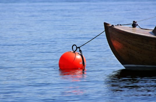 Front of small wooden boat moored with a rope.