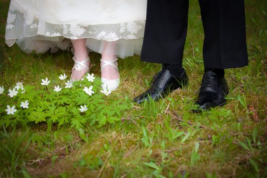 Just married couple walking on gras inside a forest