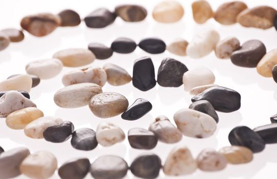 Stone spiral made from the beach pebbles isolated on the white