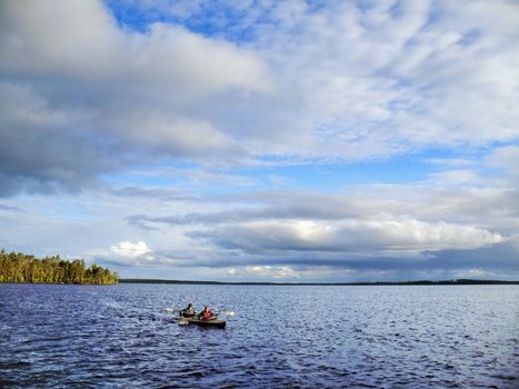 canoe travel on lake at light northern sky