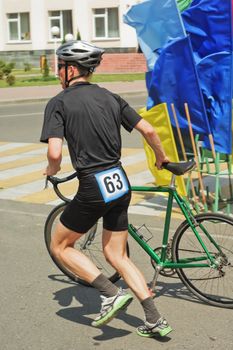 The sportsman running near  bicycle on road