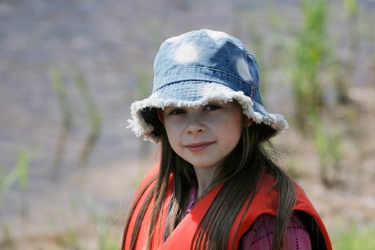 Nice, young girl with hat enjoy summer time.