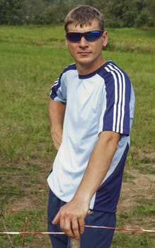 The young confident sportsman in dark blue glasses