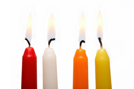 Set of four colored lighting candles on white background