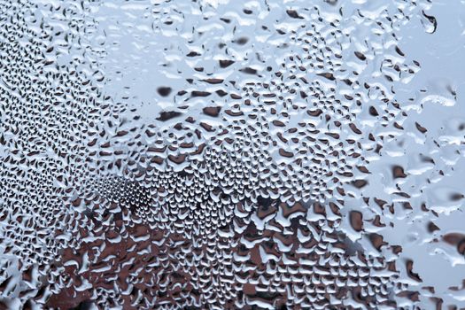 Closeup of crystal clear water drops lying on mirror background