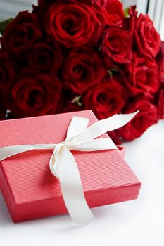Gift box over bunch of red roses