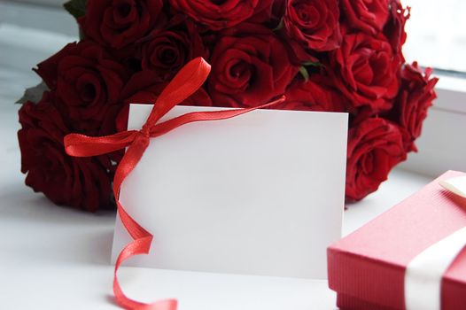 Blank note for message over bunch of red roses