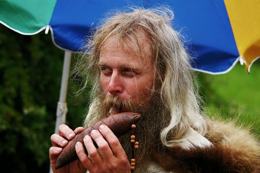 etnhic musician play
 tune on clay flute ocarina