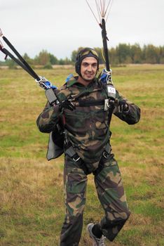 The smiling parachutist at the moment of a landing
