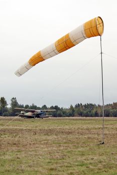 The biplane before flight on airfield  - in the foreground a wind directional marker