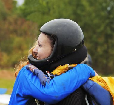 Two joyful girls embrace before parachute jump