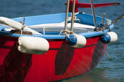 An old colored rowboat anchored in the sea