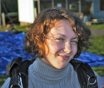 The smile girl-parachutist in a grey sweater