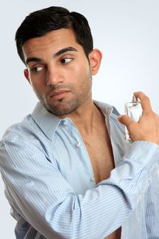 A man spritzes some aftershave cologne perfume while getting ready to go out.