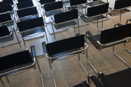 Many contemporary black chairs in a room