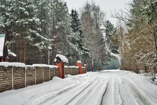 winter house with fence and snow road