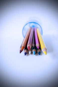 Close up of many colored pencils in a glass