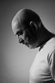 An old man with a grey beard in sorrow