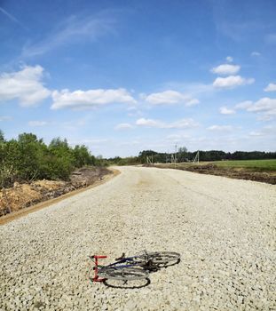 The bicycle lies on gravel laid on under construction road