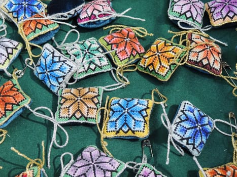 Set of the multi-colored embroidered small pillows for sewing needles