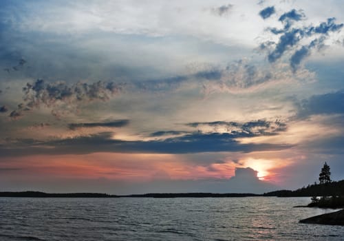 thunderstorm clouds over sunset lake