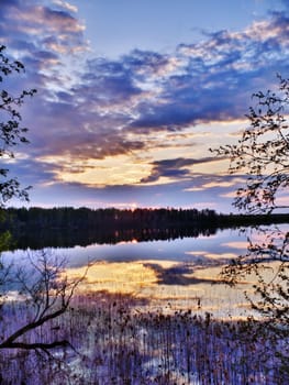 Blue cloudy sunset on spring lake