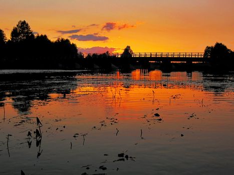 bridge through river illuminate red sunset rays