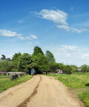 Sandy road to village, at the left wooden fence to ancient style