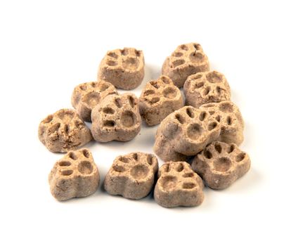 A small pile of dog treats in the form of paws, shot on a white background.