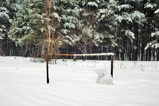 Football gate on a snow field are protected by a snowball