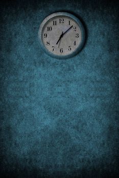 A grunge image with blue and white clock on a wall
