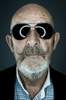 An old man with a grey beard wearing sunglasses