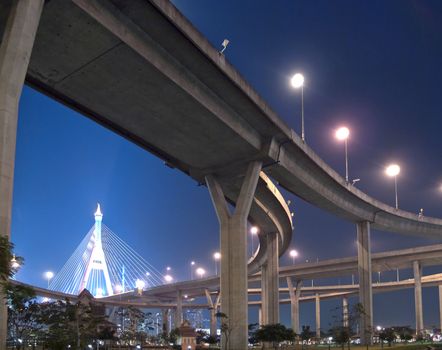 Intersection expressway with grade separation illuminate with spotlight on deep blue sky, Bhumibol Bridge, Samut Prakarn,Thailand