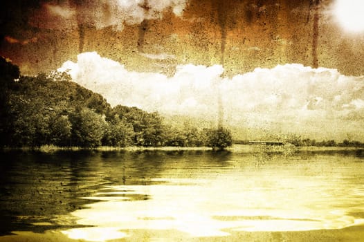 A scene of a lake and tree under a cloud blue sky