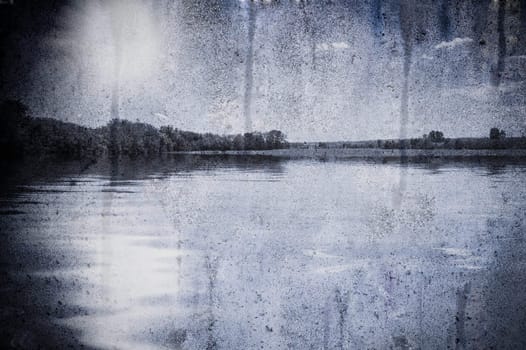 A scene of a lake and tree under a cloud blue sky