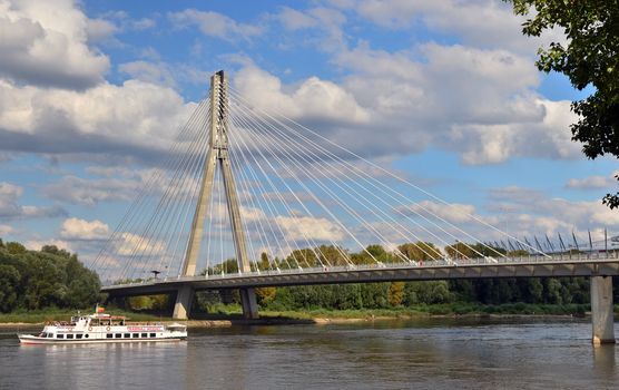Syreny bridge over Vistula in Warsaw. Water tram on the river. Passengers faces unrecognisable. Panoramic wide angle view.