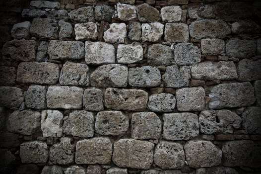 A wall of aged grey stones in line