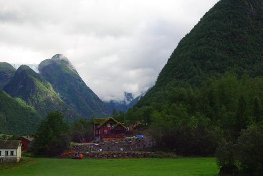 Traditional wooden houses on hillside background in Invik, Norway