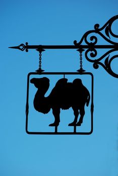 Sign with camel on blue sky background