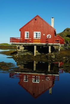 House on the sea coast and its reflection in still water