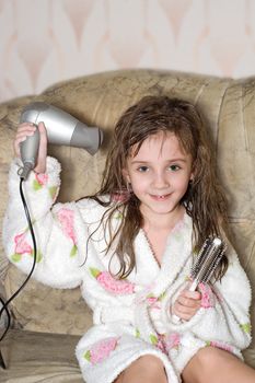 The little girl dries hair  after bathing
