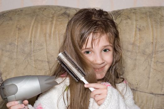 The little girl dries hair after bathing