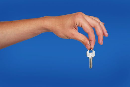 hand with metallic key on blue background.real estate theme