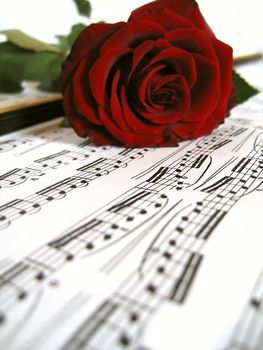 Red rose over sheet music