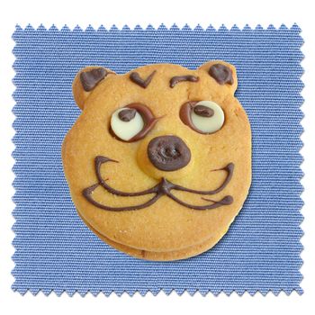Baked cookie with cat face over blue tablecloth