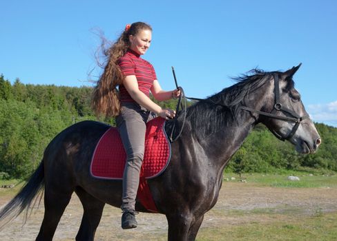 A girl riding a horse on a meadow