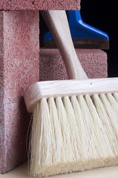 Stonemason's brush next to red bricks and a chisel.