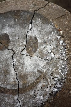 Close up detail of a painted smiley on a concrete rock.