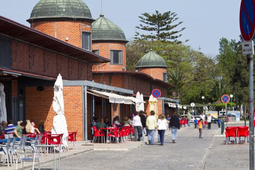 View of the traditional market area of the city of Olhao in Portugal, with people walking around.