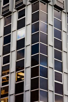 Detail view of the corner of a modern building, with a glowing window.